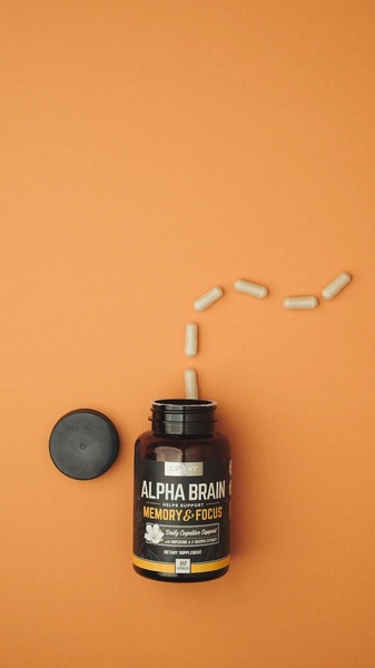 A clean, minimalist product hero shot for a memory supplement, using negative space and an organic pill arrangement to draw the eye.